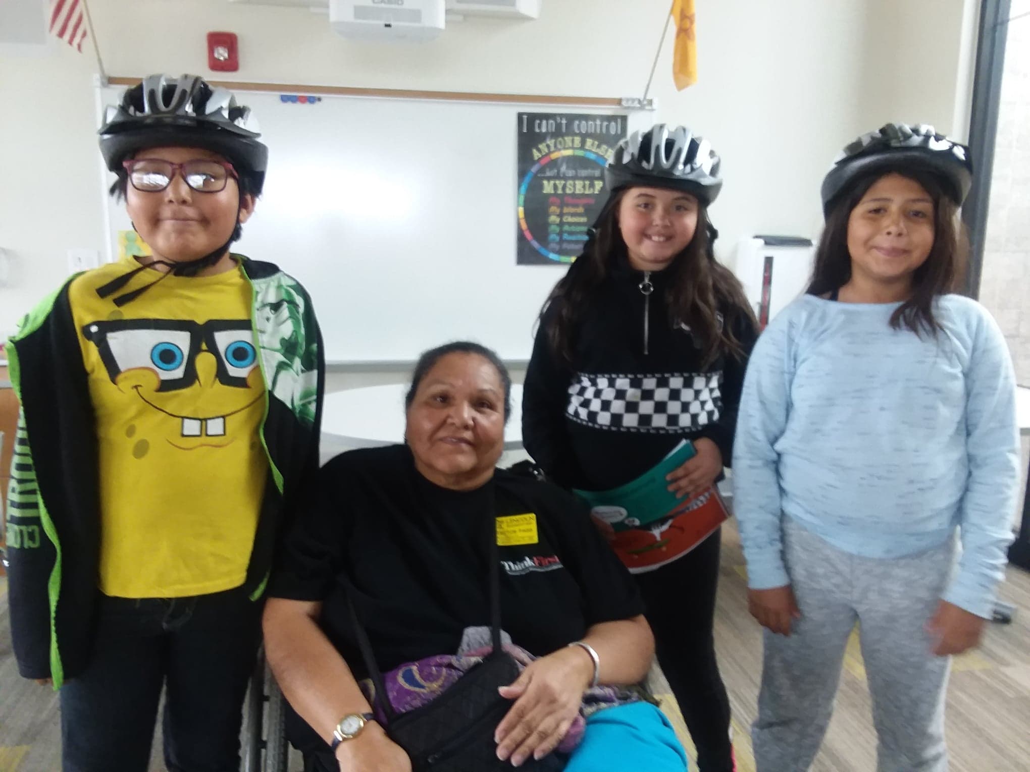 ThinkFirst Navajo VIP Cecelia Fred surrounded by smiling students from Lincoln Elementary with their new bike helmets.